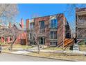 Brick apartment building with small balconies, symmetrical facade, and front yard on a sunny day at 1330 Elizabeth St # 8, Denver, CO 80206