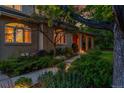 Home exterior featuring an arched porch, lush landscaping, stone pathway, and mature trees at 2558 Premier Pl, Boulder, CO 80304