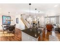 Open floorplan with a modern kitchen island, staircase, dining area and a view into the cozy living space at 3751 W 136Th Ave # S3, Broomfield, CO 80023