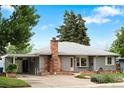 Charming single-story home with well-kept lawn, brick chimney, attached carport, and beautiful landscaping at 6755 W 45Th Ave, Wheat Ridge, CO 80033