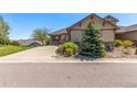 Well-kept house with a driveway, front yard, and charming curb appeal under a clear blue sky at 7580 S Biloxi Ct, Aurora, CO 80016