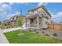 Beautiful two-story home showcasing stone accents, covered porch, professional landscaping and a lush lawn at 14818 Dahlia St, Thornton, CO 80602
