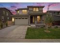 Attractive two-story home with stone accents and a front porch, beautifully illuminated at twilight at 14818 Dahlia St, Thornton, CO 80602