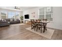 Bright open-plan living room with wood floors, stylish furnishings, and lots of natural light at 14818 Dahlia St, Thornton, CO 80602