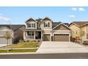 Charming two-story home with a three-car garage, covered porch, and a well-manicured lawn at 13041 Reata Ridge Dr, Parker, CO 80134
