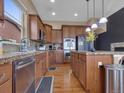 Gourmet kitchen featuring stainless steel appliances, wood cabinets, and granite countertops at 413 N De Gaulle Ct, Aurora, CO 80018