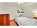 Bedroom with white walls features a bed, hardwood floors, a window and modern dresser at 1241 Wabash St, Denver, CO 80220