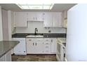 Bright kitchen features white cabinets, granite countertops, and modern appliances at 13952 E Marina Dr # 304, Aurora, CO 80014