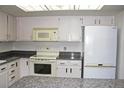 Bright kitchen features white cabinets, granite countertops, and modern appliances at 13952 E Marina Dr # 304, Aurora, CO 80014