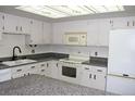 Cozy kitchen with white cabinets, granite countertops, and a unique ceiling fixture at 13952 E Marina Dr # 304, Aurora, CO 80014
