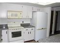 Bright kitchen features white cabinets, granite countertops, and modern appliances at 13952 E Marina Dr # 304, Aurora, CO 80014