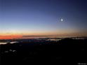 Stunning night view showcasing city lights under a vibrant twilight sky with a bright moon at 6057 Red Hill Rd, Boulder, CO 80302