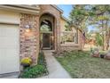 Close up view of the front entrance, with brick accents, a walkway, and well-maintained landscaping at 25875 Buffalo Ln, Golden, CO 80401