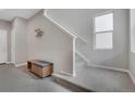 Bright entryway featuring neutral walls, carpeted stairs, bench, and a modern coat rack at 8982 Delacorte St, Littleton, CO 80129