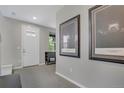 Neutral entryway with white door and modern artwork, creating a welcoming ambiance at 8982 Delacorte St, Littleton, CO 80129