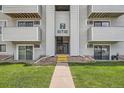 Apartment building entrance with number 7 and unit numbers is bordered by grassy lawn at 10150 E Virginia Ave # 301, Denver, CO 80247