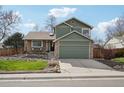 Charming two-story home with a lush green lawn, stone accents and a two car garage at 6167 S Pierson St, Littleton, CO 80127