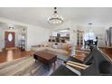 Bright, open living room with hardwood floors, modern lighting, and seamless kitchen access at 18714 E Utah Cir, Aurora, CO 80017