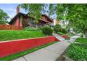 Two-story home featuring a well-manicured lawn, brick facade, and charming front porch at 2131 Eliot St, Denver, CO 80211