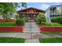 Inviting two-story home with a brick facade, landscaped yard, and prominent staircase at 2131 Eliot St, Denver, CO 80211