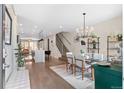 Open dining area with contemporary chandelier, glass table, and stylish decor leading to the kitchen at 3885 Vrain St, Denver, CO 80212
