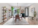 Bright dining area with a glass table, stylish chandelier, and shelving, filled with natural light at 3885 Vrain St, Denver, CO 80212