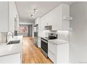 Modern kitchen showcases white cabinets, stainless steel appliances, and sleek countertops, offering a contemporary design at 12893 W Alameda Dr, Lakewood, CO 80228