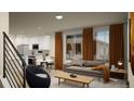 Comfortable living room space with a modern sofa, stylish decor, and bright natural light at 46517 Sunflower Ln, Bennett, CO 80102