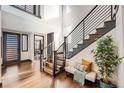 Bright foyer featuring hardwood floors, a staircase with black railings, and stylish decor at 14209 Beebalm Loop, Parker, CO 80134