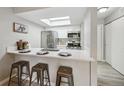 Bright kitchen featuring stainless steel appliances, white cabinetry, and a modern quartz countertop with bar seating at 4274 S Salida Way # 6, Aurora, CO 80013