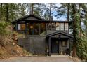 Stunning exterior view of a modern home nestled among mature trees and natural landscaping at 7869 S Turkey Creek Rd, Morrison, CO 80465