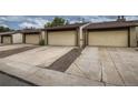 Rear view of townhouses showcasing attached garages and parking at 6594 W Mississippi Way, Lakewood, CO 80232