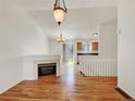 Bright living room featuring hardwood floors, vaulted ceilings, and a fireplace at 5280 E 128Th Way, Thornton, CO 80241