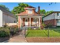 Charming two-story brick home featuring a cozy front porch and well-manicured lawn at 3016 N Franklin St, Denver, CO 80205