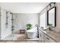 Modern bathroom featuring a freestanding tub, glass shower, and stylish vanity with stone countertops at 1280 Galactic Pl, Castle Rock, CO 80108