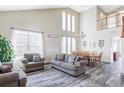 Spacious living room featuring high ceilings, lots of windows, and wood-look flooring at 1280 Galactic Pl, Castle Rock, CO 80108