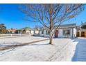 Exterior view of house with snow-covered yard and sidewalk leading to the red door at 1708 Oswego St, Aurora, CO 80010