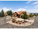 Stunning exterior elevation with professional landscaping showcasing the beautiful circular drive leading up to the home at 6170 Falcon Ln, Morrison, CO 80465