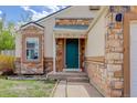Close-up of front door with stone details and walkway at 11420 E 1St Ave, Aurora, CO 80010