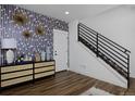 Stylish entryway with decorative wallpaper, console table, and black metal staircase railing at 10864 Lyric St, Lone Tree, CO 80134