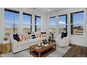 Bright living room with large windows offering outdoor views and comfortable seating arrangements with a coffee table at 10864 Lyric St, Lone Tree, CO 80134
