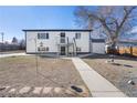 View of backyard including bird bath, storage building, walkway and mature trees at 111 Wolff St, Denver, CO 80219