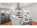 Bright kitchen featuring stainless steel appliances, an island with seating, and a modern range hood at 111 Wolff St, Denver, CO 80219