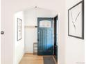 Inviting entryway featuring a blue front door, light wood floors, and modern decor at 3445 N Clay St, Denver, CO 80211