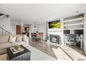 Bright living room boasts a fireplace, TV, desk, and open layout to dining area and kitchen, great for modern living at 3471 S Ammons St # 12-6, Lakewood, CO 80227