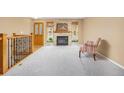 Bright living room featuring a stone fireplace, large windows, and neutral carpet at 2871 Humboldt Cir, Longmont, CO 80503