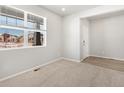 Bright bedroom with natural light, neutral carpet, and a view of the neighborhood at 6140 Hourglass Dr, Brighton, CO 80601