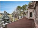 Spacious wooden deck with white railings, offering views of a well-manicured yard and mature trees at 101 Glenmoor Ln, Cherry Hills Village, CO 80113