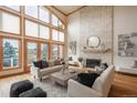 Comfortable living room featuring hardwood floors, a stone fireplace, high ceilings and natural light at 101 Glenmoor Ln, Cherry Hills Village, CO 80113