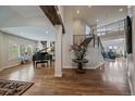 Spacious living room with hardwood floors, grand piano, staircase, and open floor plan at 1366 Killington Ct, Evergreen, CO 80439